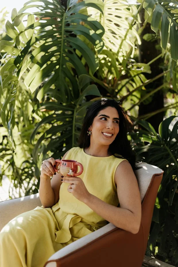 Dra. Lygia Monnerat sorrindo, segurando uma xícara