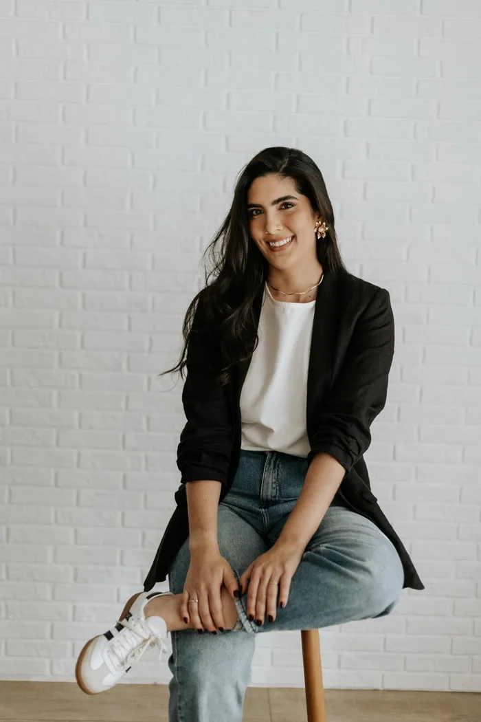 Dra. Lygia Monnerat de blazer preto, sentada, sorrindo